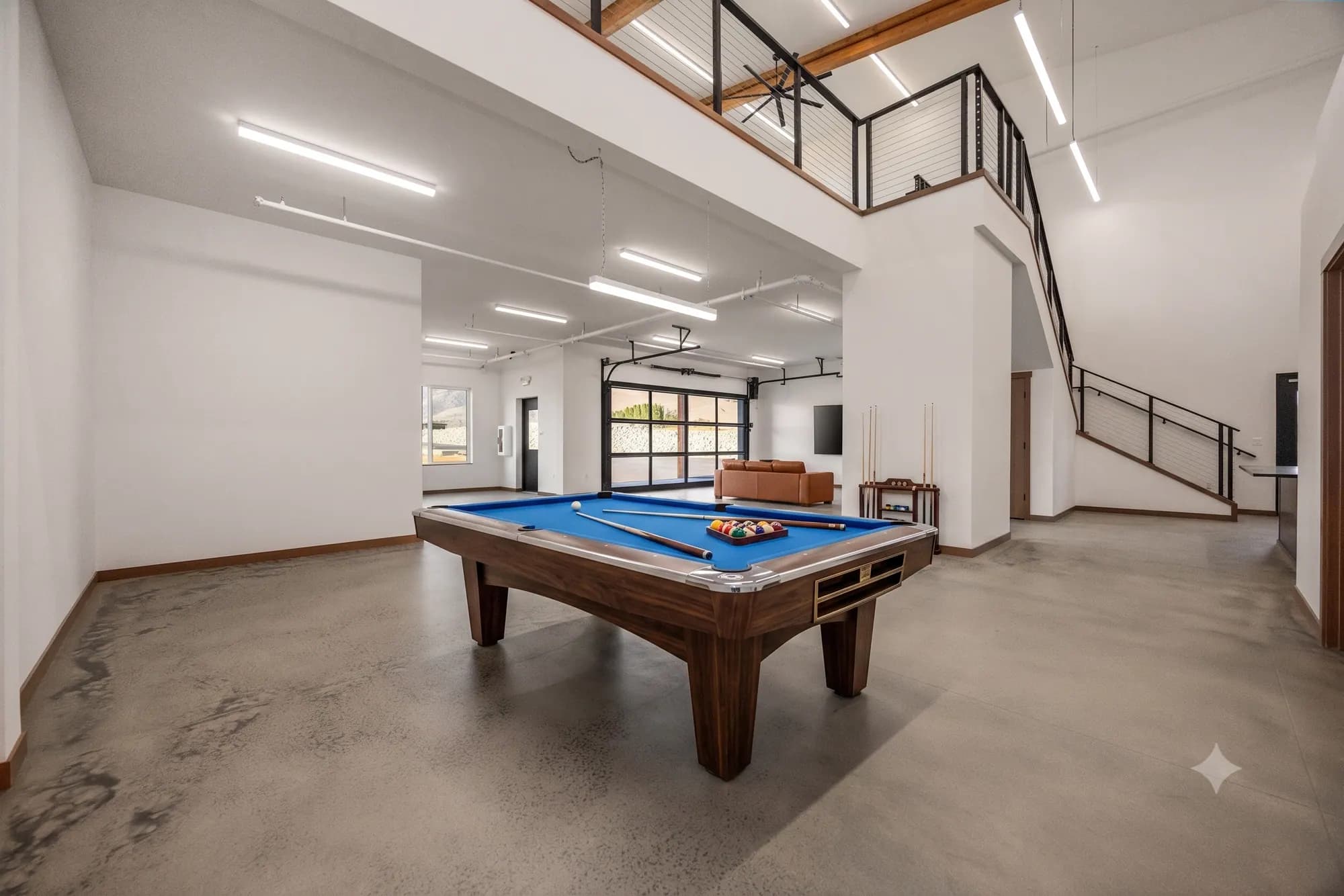 Clubhouse billiards lounge with leather seating and glass garage door